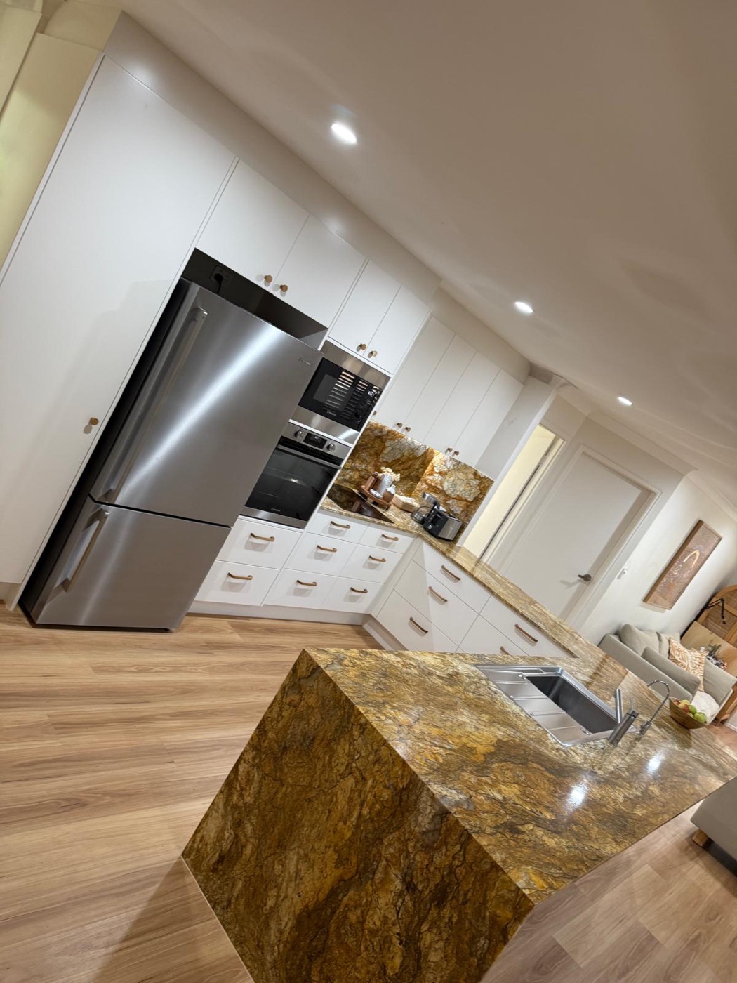 White kitchen with granite benchtop, integrated ovens and full-height storage
