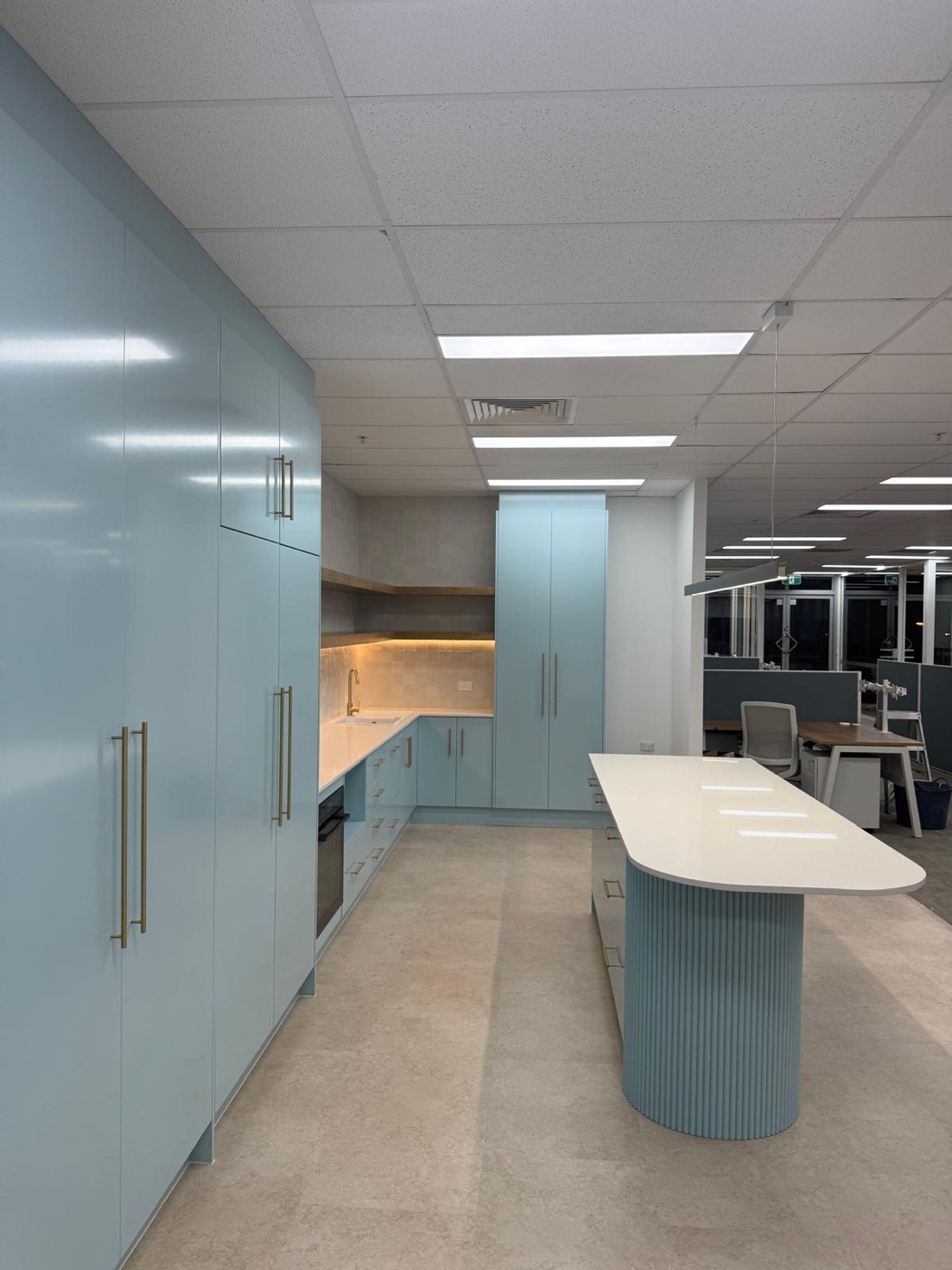 Duck-egg blue kitchenette with brass handles and full-height cabinetry